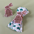 pair of rattan bunny napkin rings with one on a green dinner napkin