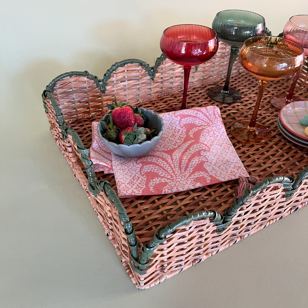 green rattan serving tray styled with champagne glasses side detail