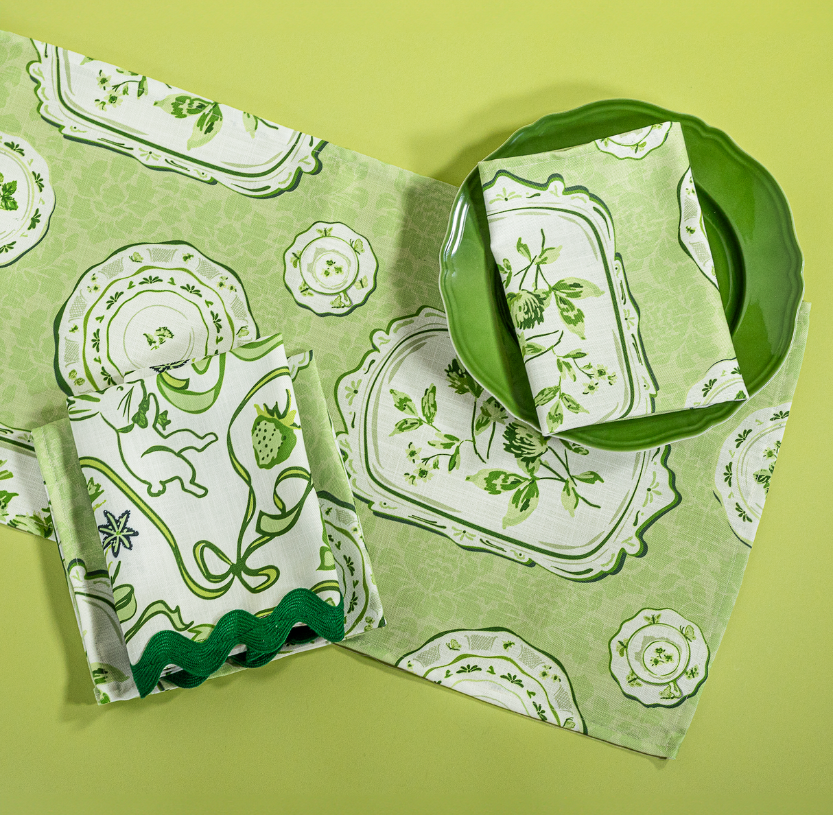 Green table runner in a vintage plates print fabric with matching napkins. 