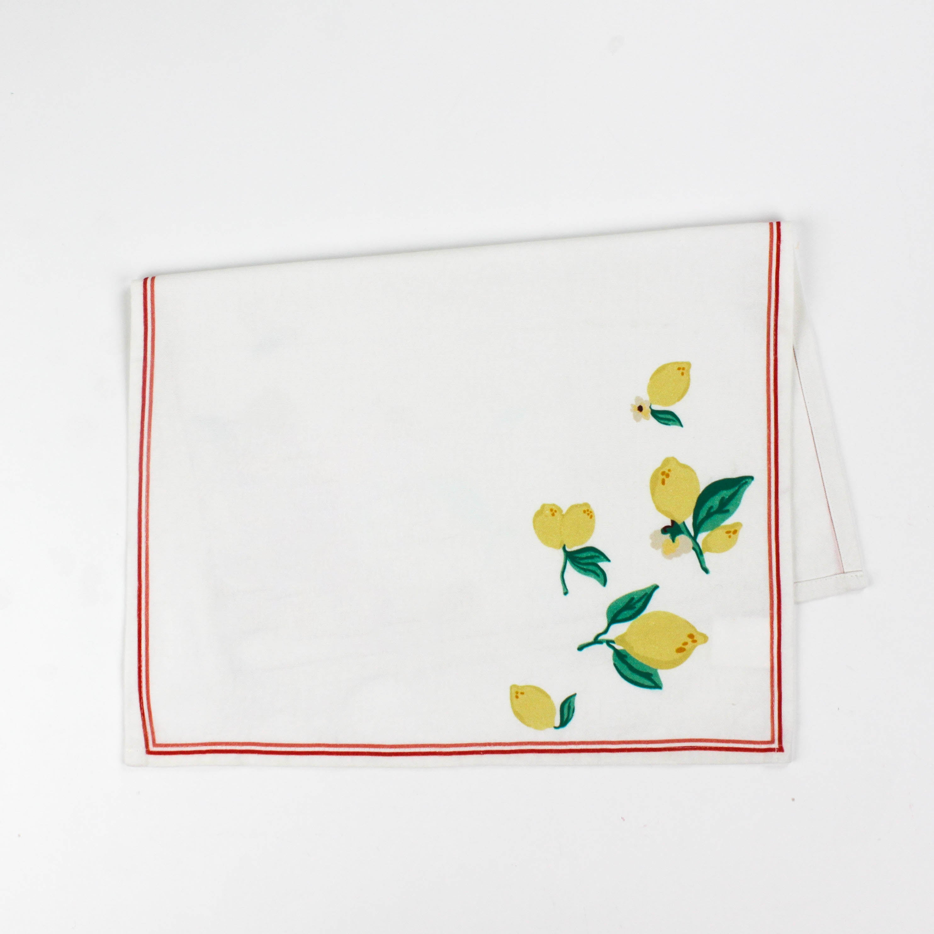 White Christmas tea towel decorated with yellow lemons and green leaves along the edges, bordered by a thin red outline