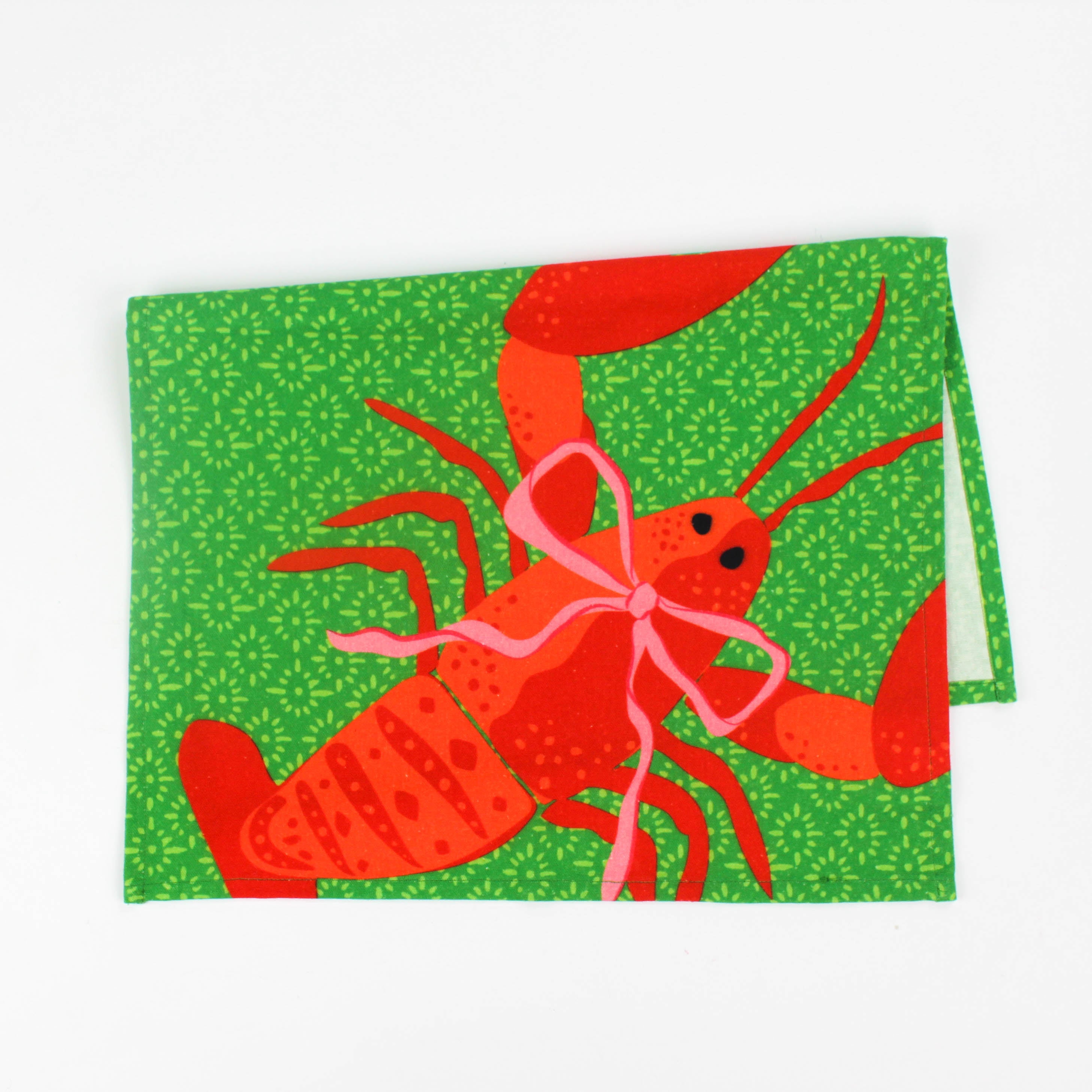 Green Christmas tea towel with a festive red lobster illustration tied with a pink bow