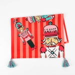 Christmas tea towel featuring colorful nutcracker soldier  with striped background