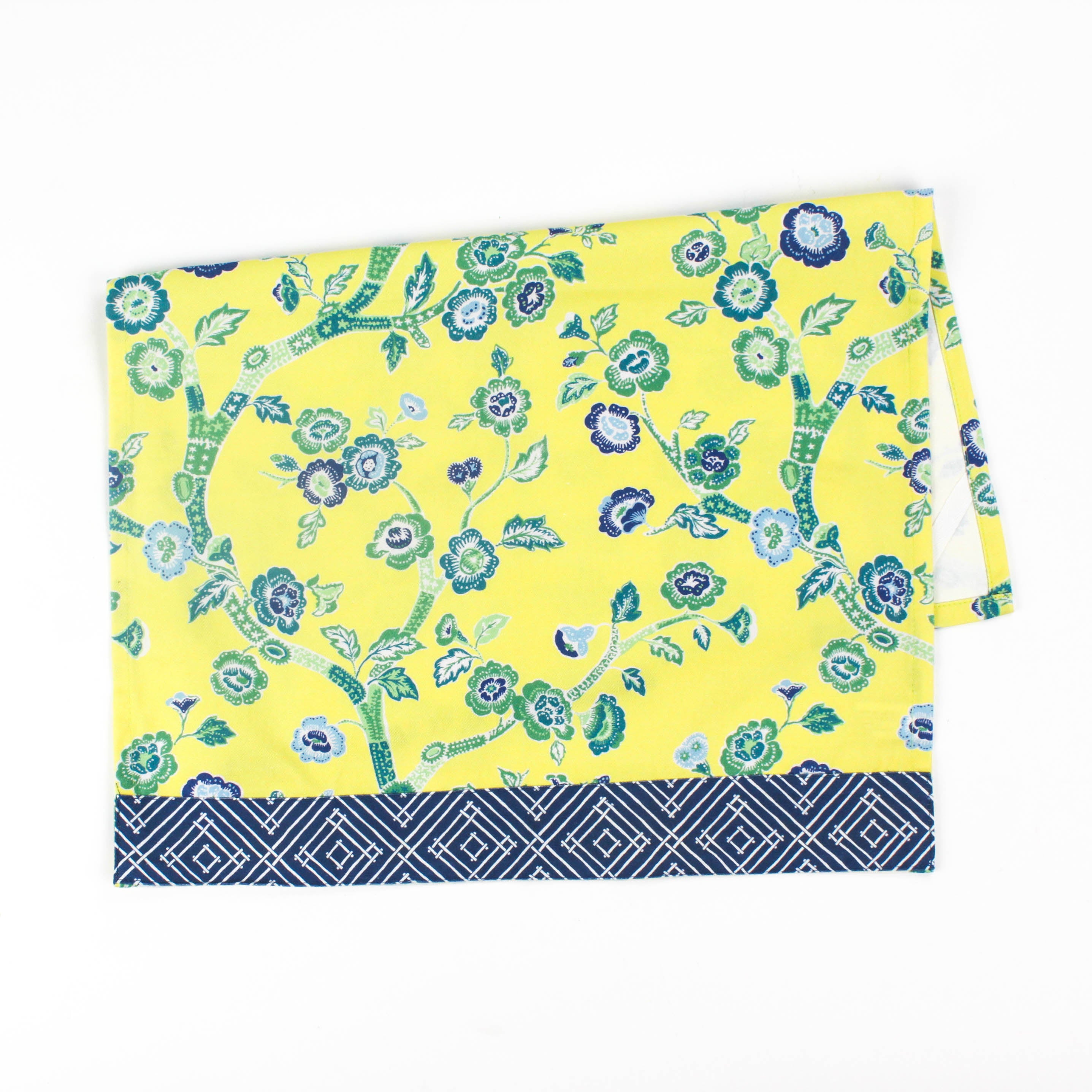 Christmas tea towel with a bright yellow background featuring a blue and green floral chinoiserie pattern