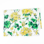 Christmas tea towel with a cheerful yellow and green floral geranium pattern on a white background