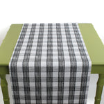 a green table covered with a black paper table runner in a black and white gingham pattern from madcap cottage