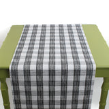 a green table covered with a black paper table runner in a black and white gingham pattern from madcap cottage