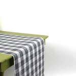 a green table covered with a black paper table runner in a black and white gingham pattern from madcap cottage