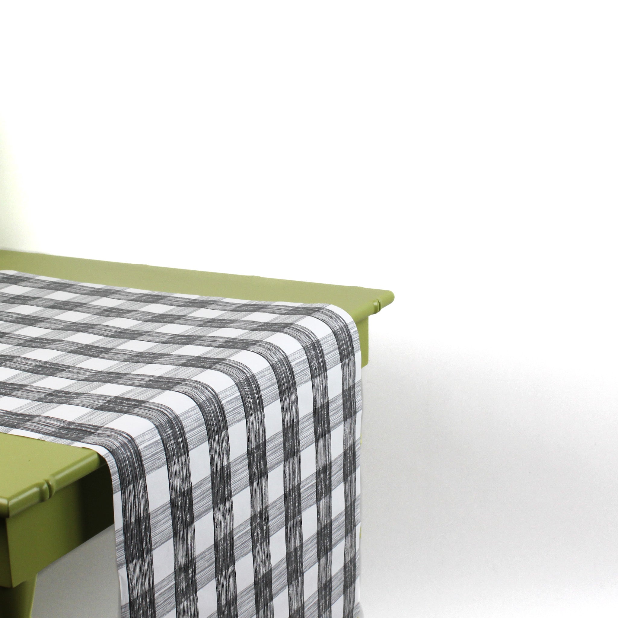 a green table covered with a black paper table runner in a black and white gingham pattern from madcap cottage