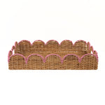 A rectangular woven rattan tray with scalloped edges and pink rope trim on a plain white background.