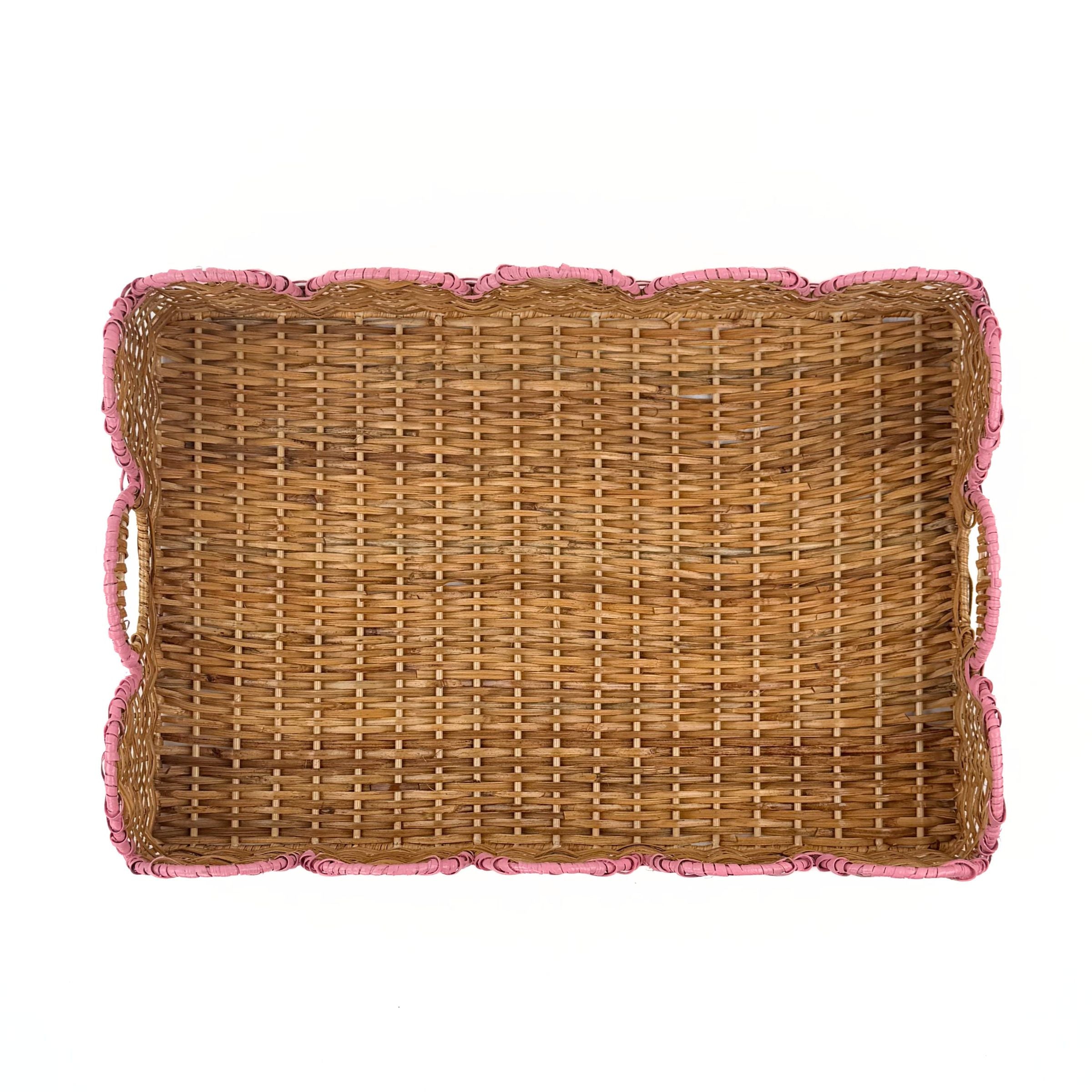 Bottom view of a rectangular woven rattan tray with scalloped edges and pink rope trim on a plain white background.