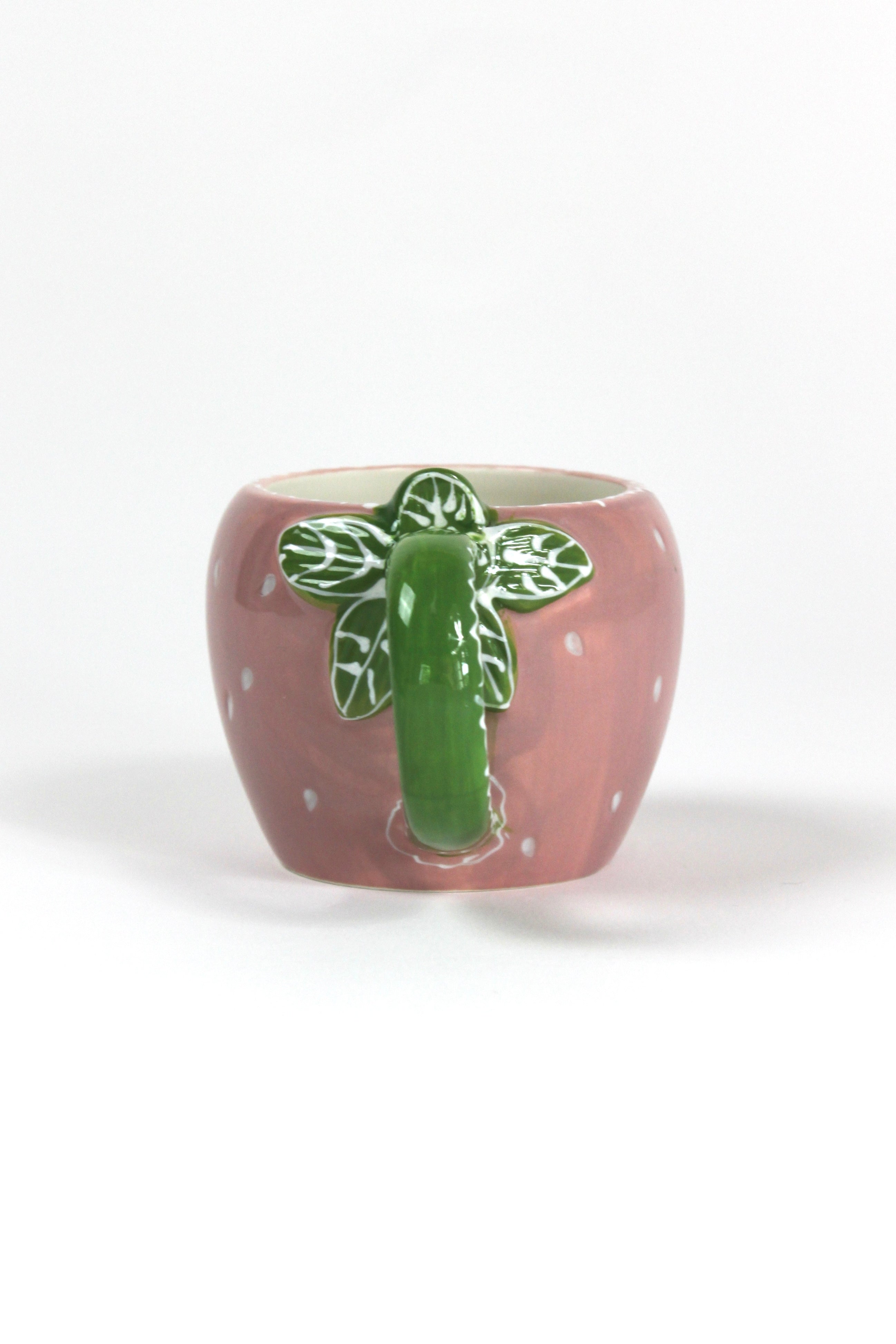 a pink ceramic strawberry mug with a green leafy handle