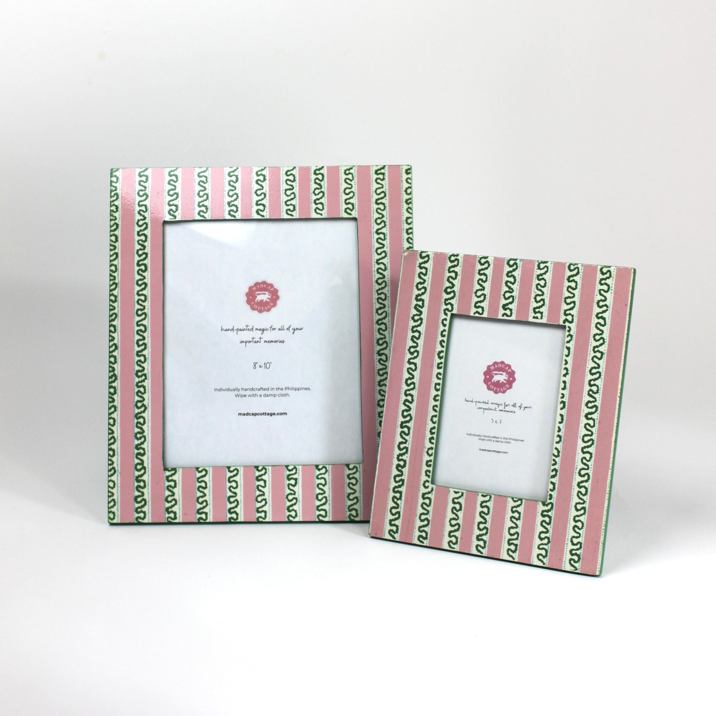 a set of two Hand painted picture frames featuring a pink and white striped motif