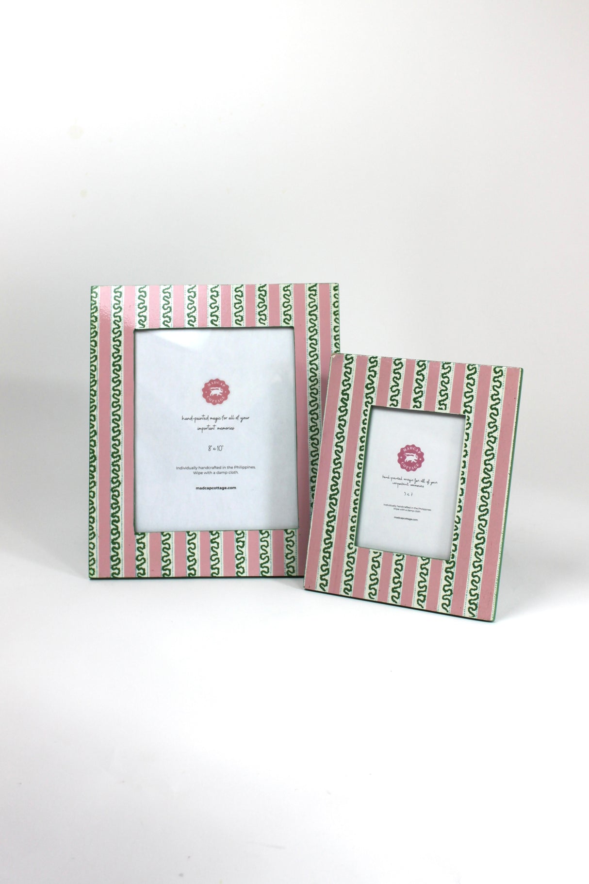 a set of two Hand painted picture frames featuring a pink and white striped motif