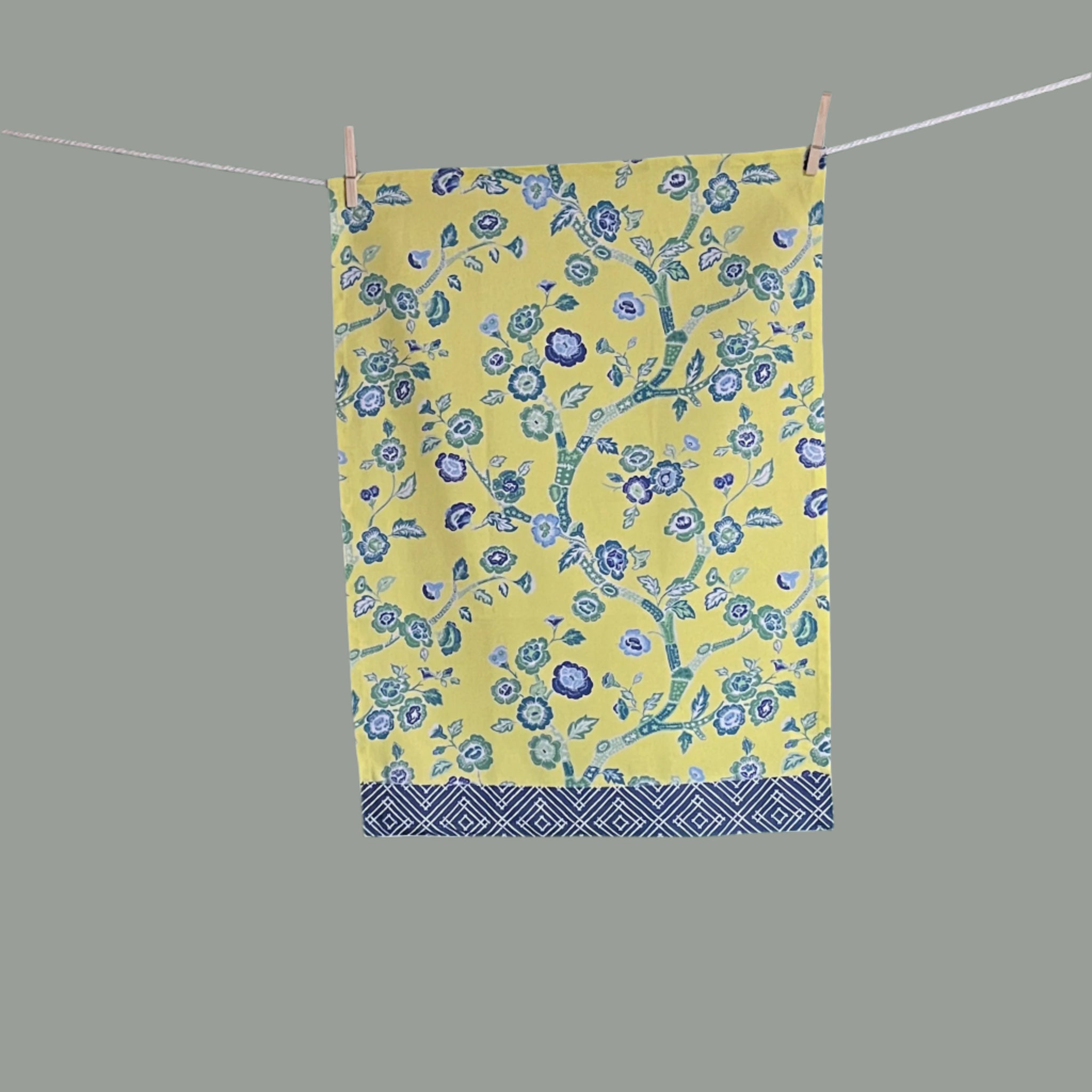 a yellow chinoiserie tea towel with blue cherry blossom motifs.