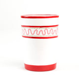 a hand-made white glasses with red stripe and pink pattern in a white background