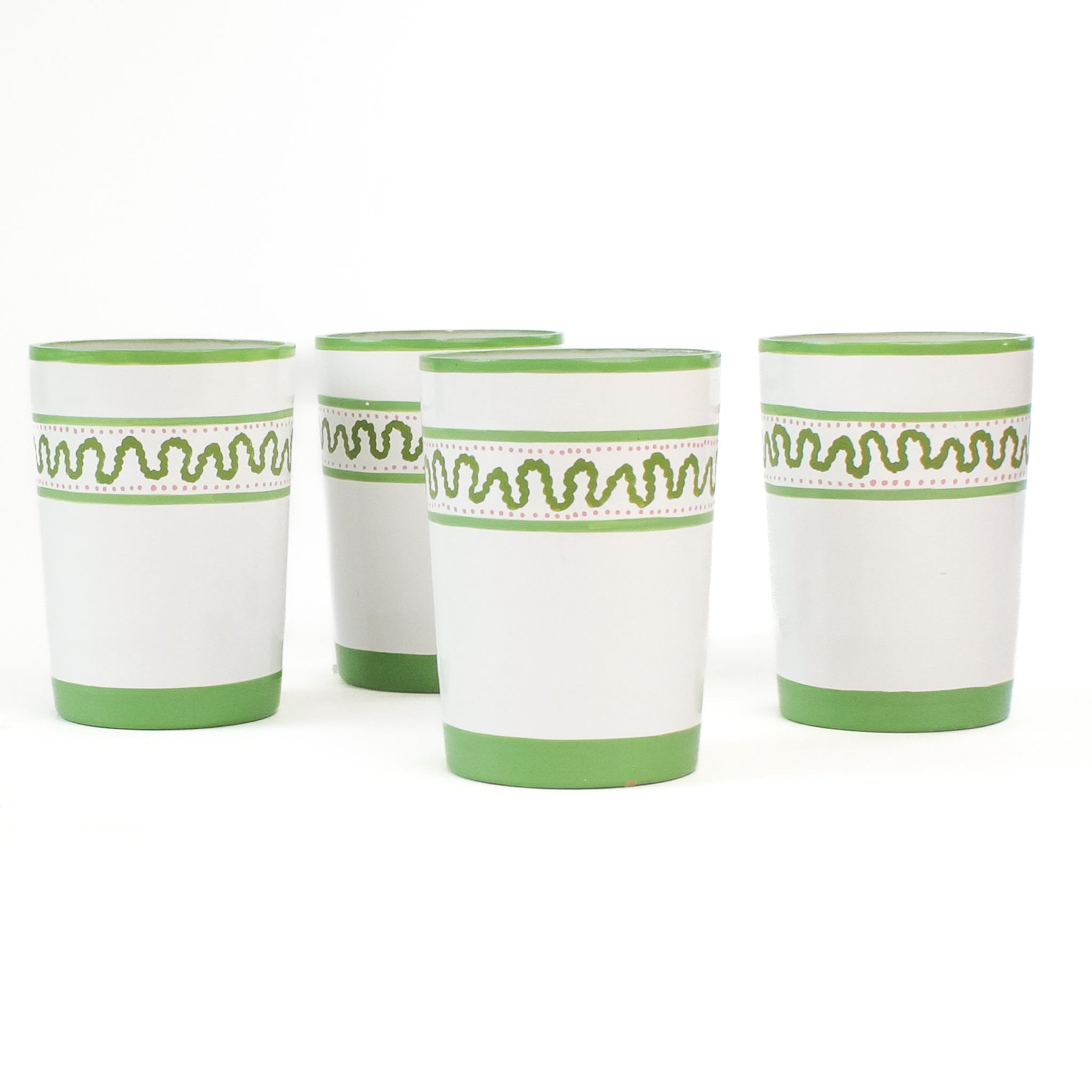 set of 4 hand-made white glasses with green stripe and wavy pattern in a white background