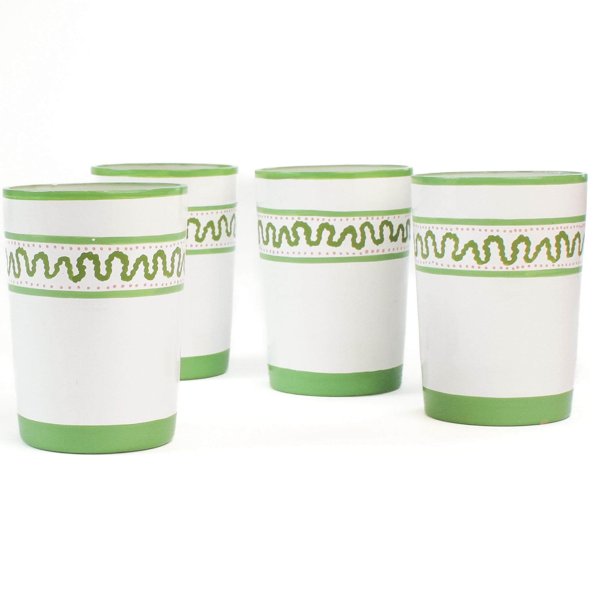 a set of 4 hand-made white glasses with green stripe and wavy pattern in a white background