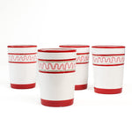 four hand-made white glasses with red stripe and pink pattern in a white background