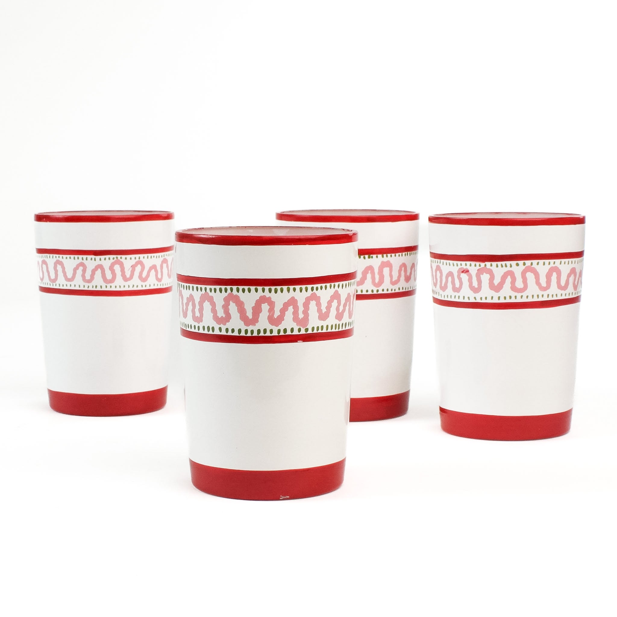 four hand-made white glasses with red stripe and pink pattern in a white background