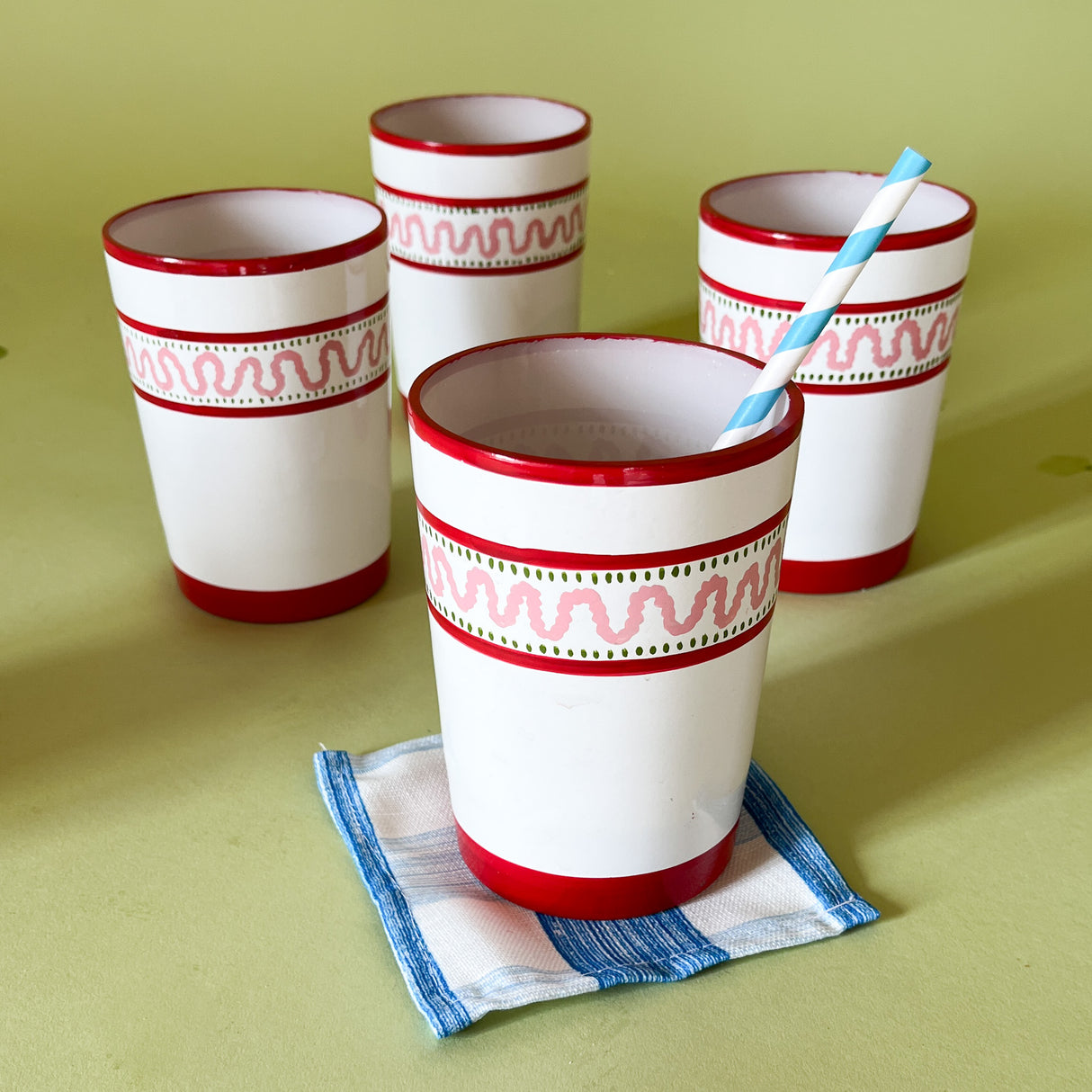 four hand-made white glasses with red stripe and pink pattern