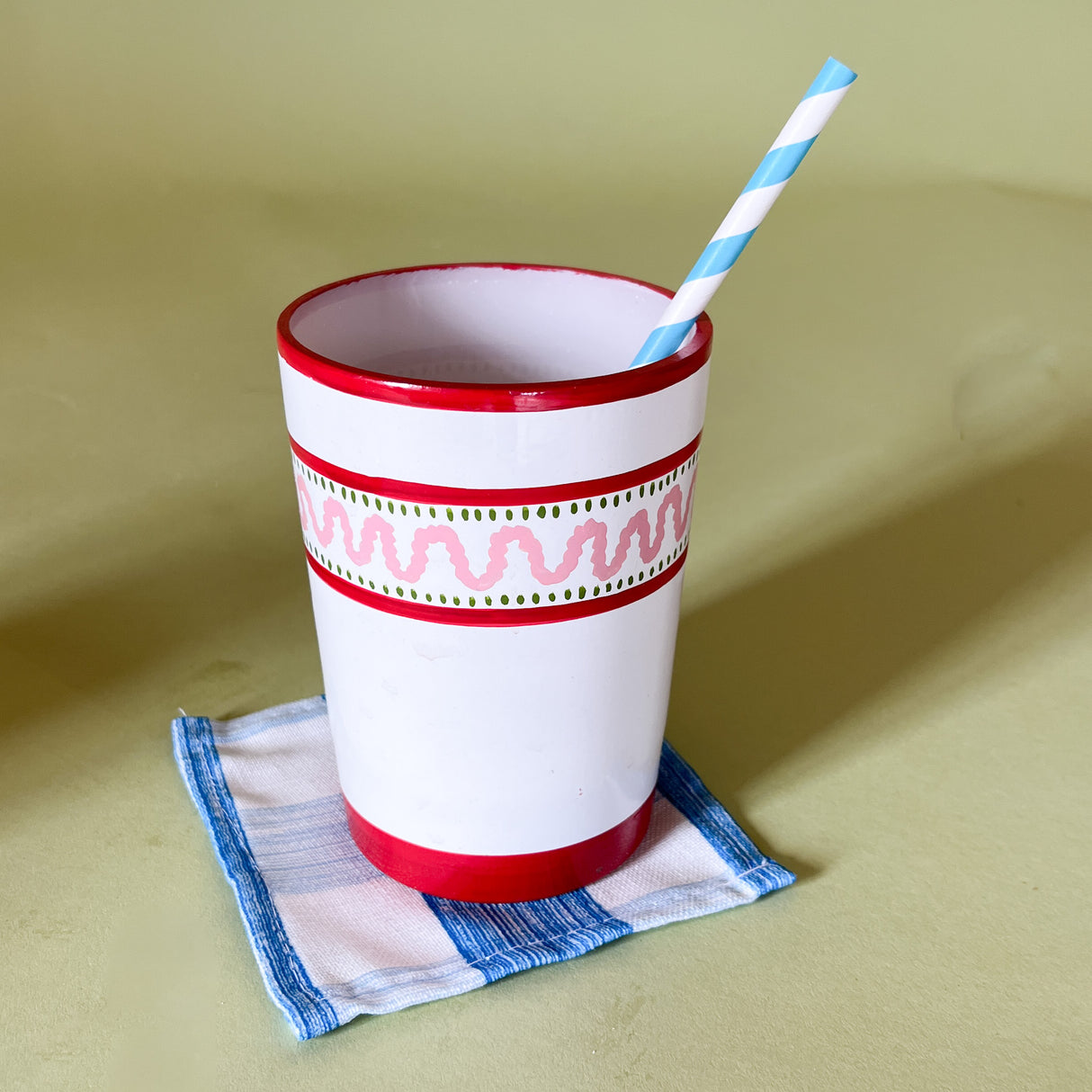 a hand-painted white glass with red stripe and pink wavy design