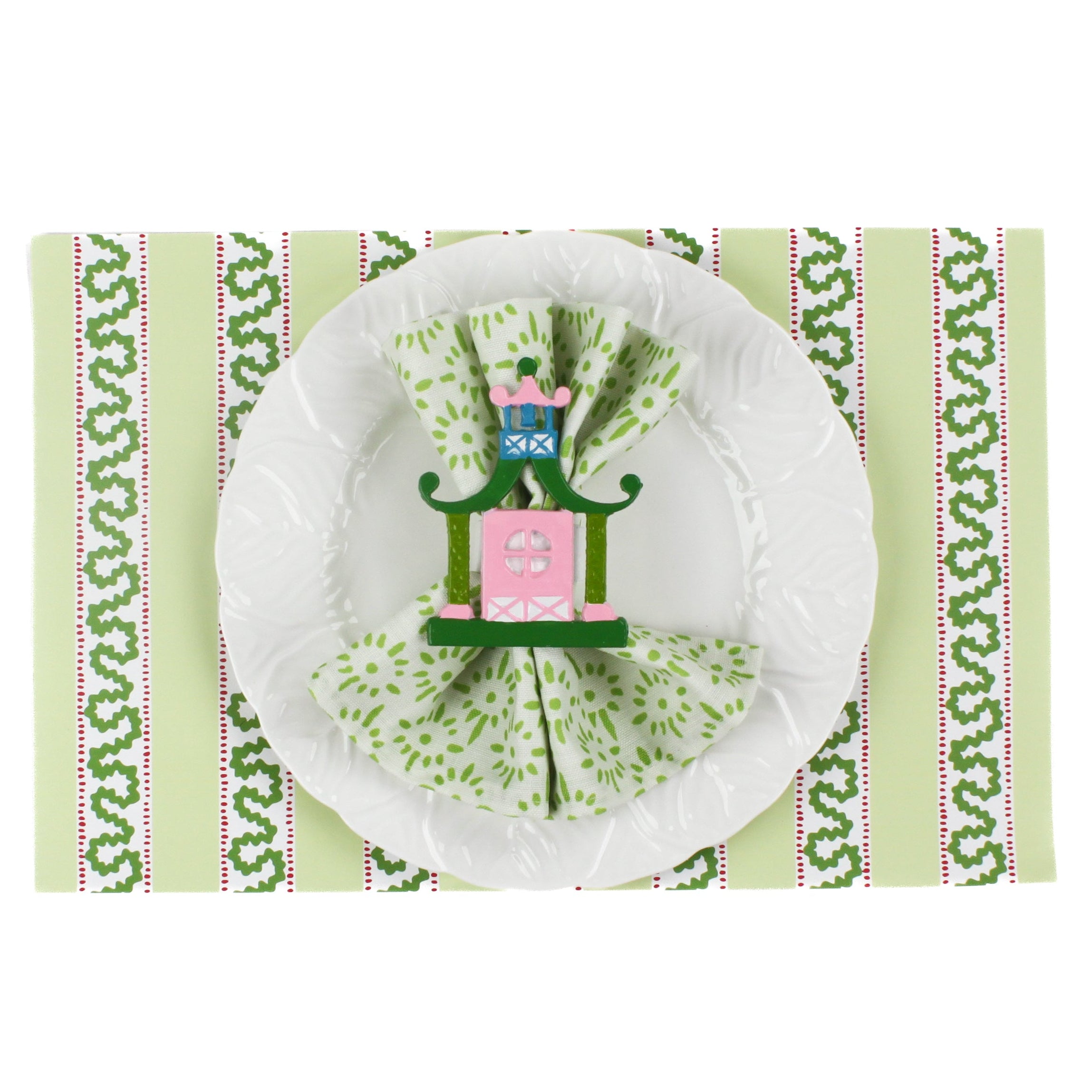 a green paper placemats featuring a striped pattern in a white background. A white plate is placed on top of it with a cloth and a nutcracker napkin ring