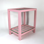 A pink side table with a green and white striped pattern named "Harbor Trail" by madcap cottage