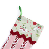 Decorative striped red and pink Christmas stocking with a green cuff with pugs on it on a white background