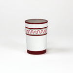 a red painted glass with a squiggly motif at the top called "Harbor Trail" by madcap cottage