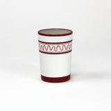 a red painted glass with a squiggly motif at the top called "Harbor Trail" by madcap cottage