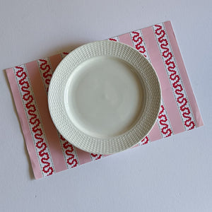 red and pink paper placemats featuring a striped pattern from Madcap Cottage