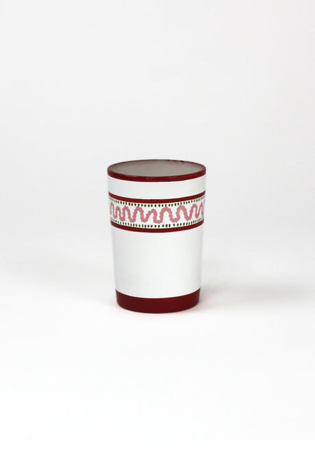 a red painted glass with a squiggly motif at the top called "Harbor Trail" by madcap cottage