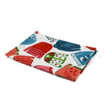a christmas tea towel featuring a repeating holiday sweater design in red, pink and blue