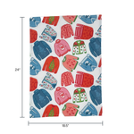 a christmas tea towel featuring a repeating holiday sweater design in red, pink and blue with dimension notation of 24" x 18.5"