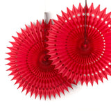 A red honeycomb paper fan decoration with a starburst design hanging against a white background.