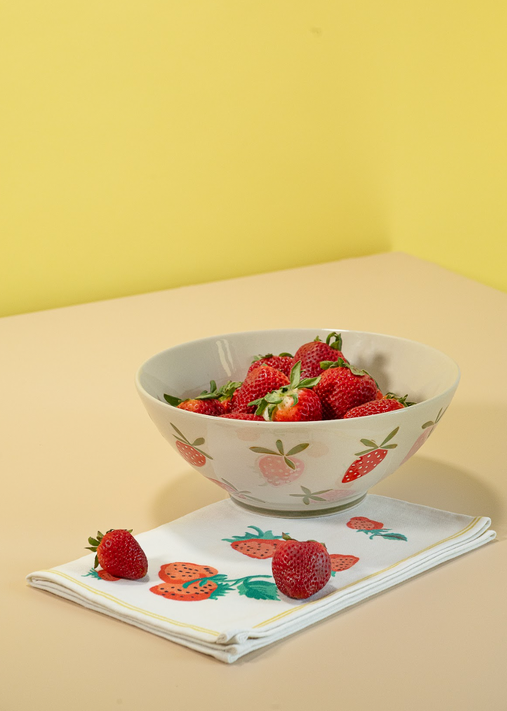 A large strawberry serving bowl with white and pink strawberry motifs decorating the exterior
