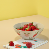A large strawberry serving bowl with white and pink strawberry motifs decorating the exterior