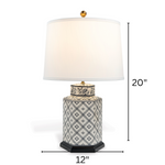 A small blue and white table lamp with a white lampshade with arrows denoting dimensions 20" high x 12" wide