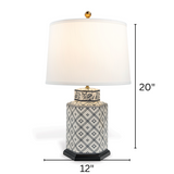 A small blue and white table lamp with a white lampshade with arrows denoting dimensions 20" high x 12" wide