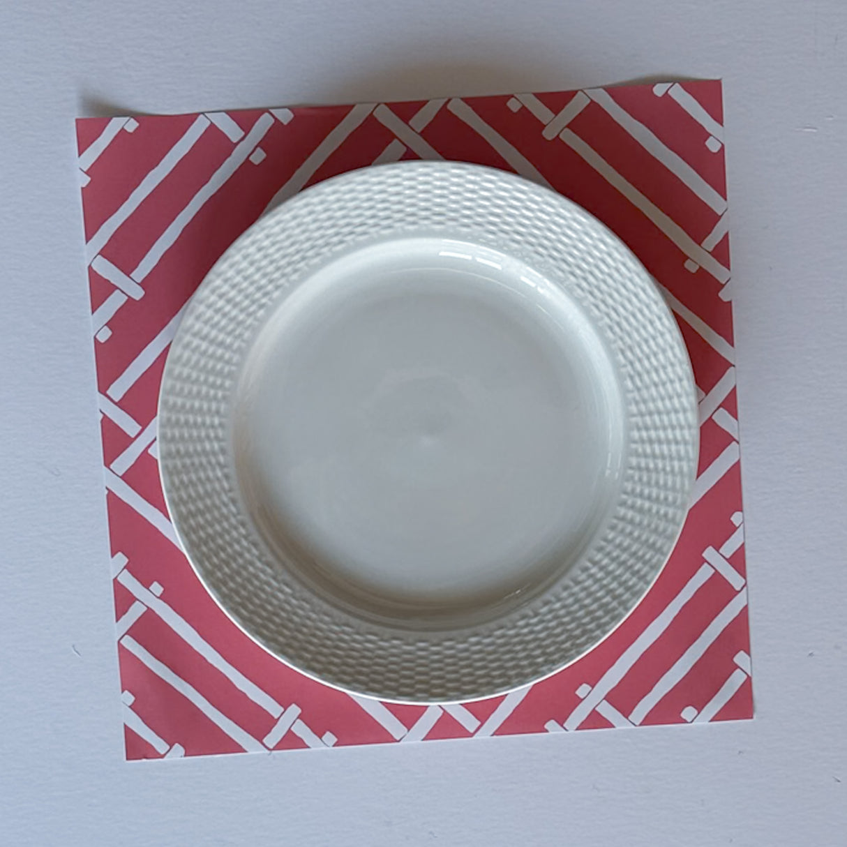 a hot pink paper placemat with a white bamboo design called island house by madcap cottage