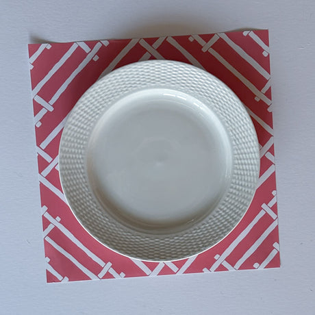 a hot pink paper placemat with a white bamboo design called island house by madcap cottage