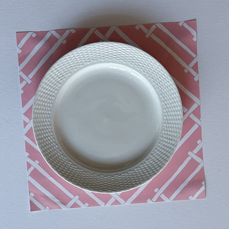 a pink paper placemat with a white bamboo design called island house by madcap cottage