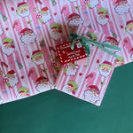 Colorful Christmas wrapping paper featuring santa, candy cane and christmas tree motifs. 