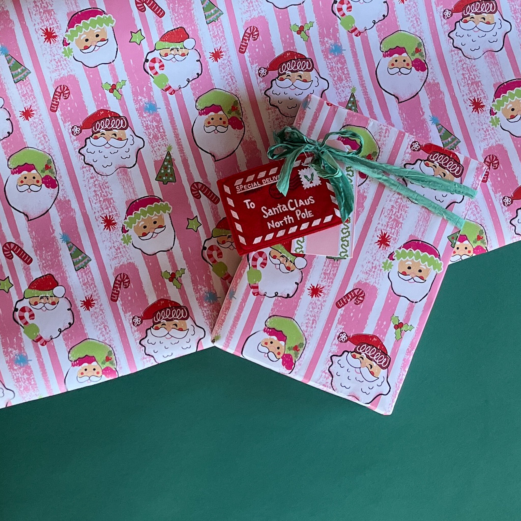 Colorful Christmas wrapping paper featuring santa, candy cane and christmas tree motifs. 