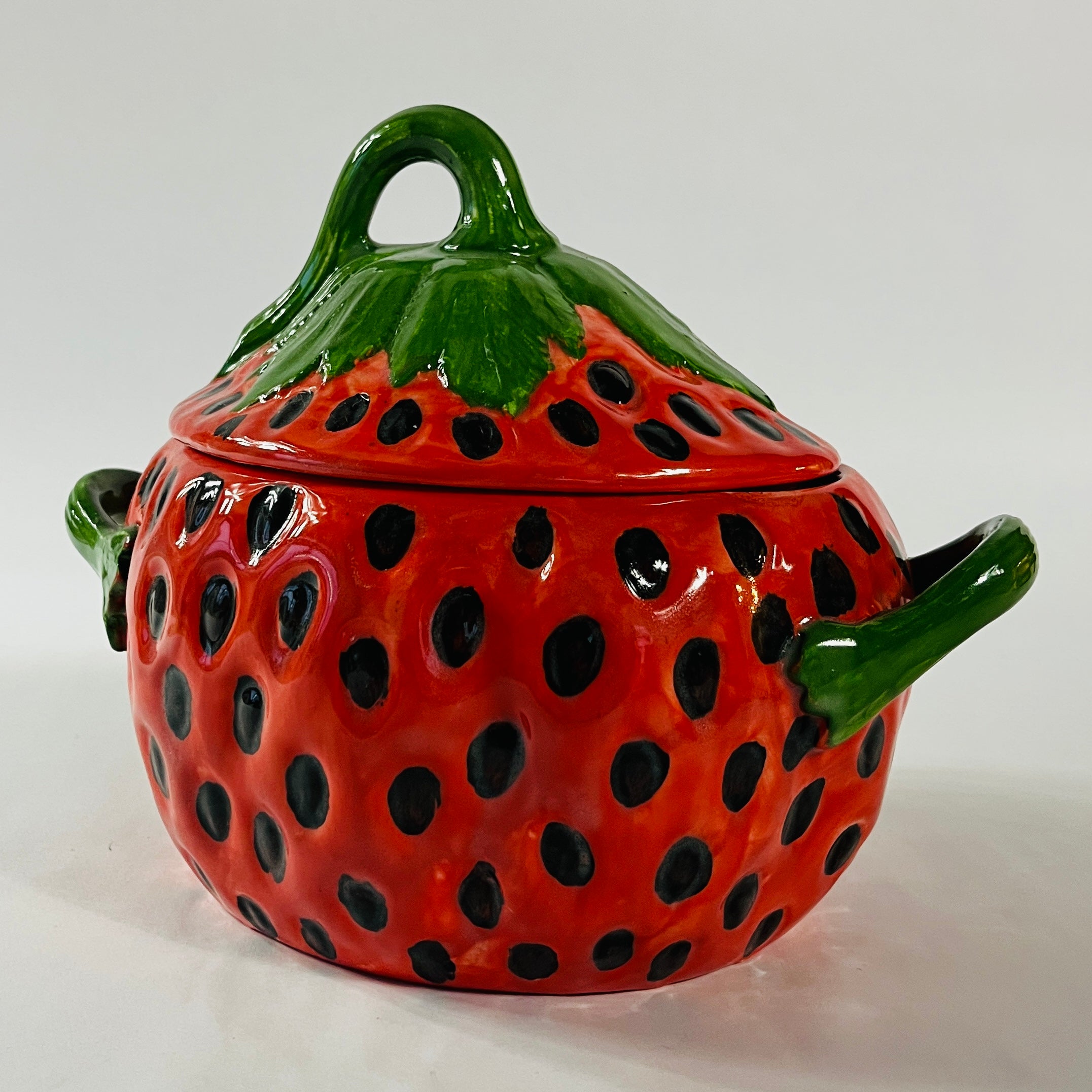 A large red vintage bowl in the shape of a strawberry