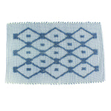 A blue/green accent rug with a lattice pattern on it