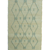 A madcap cottage yellow and green striped accent rug with a lattice motif across the front