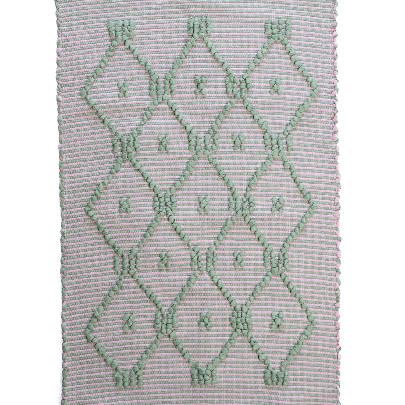 A madcap cottage pink and green striped accent rug with a lattice motif across the front
