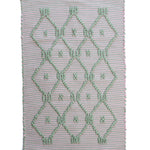 A madcap cottage pink and green striped accent rug with a lattice motif across the front