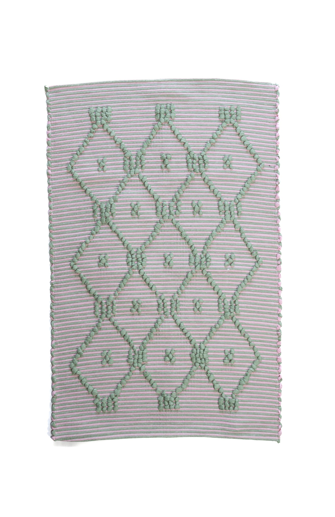 A madcap cottage pink and green striped accent rug with a lattice motif across the front